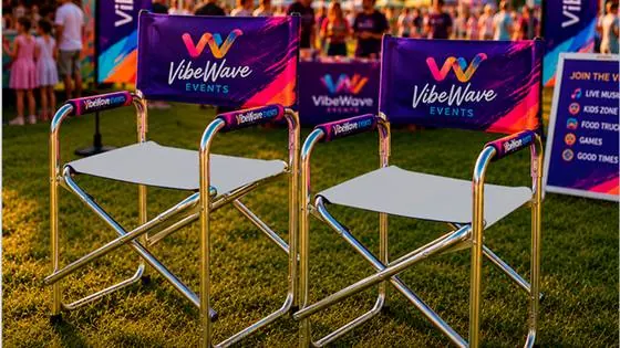 Branded directors chairs, gazebo and flag banners set up at an evening event