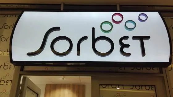 Curved illuminated Sorbet light box sign above a shopfront entrance