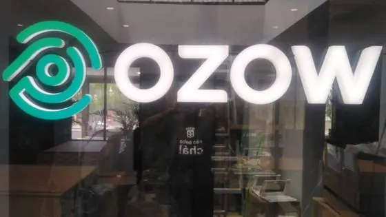Illuminated face-lit OZOW logo and lettering mounted on a glass shopfront